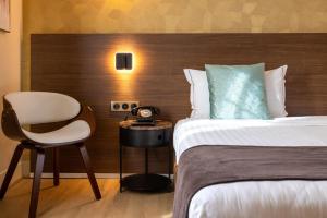 a hotel room with a bed and a chair at Hotel Parc Eiffel in Paris