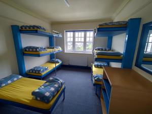 a room with four bunk beds and a desk at Adventure Bude in Bude +1 photo