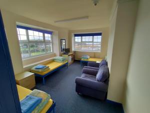 a room with two beds and a couch and a chair at Adventure Bude in Bude