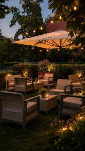 a patio with chairs and an umbrella and lights at CZECH INN Hotel Ferenc in Budapest