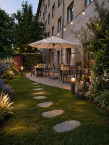 a garden with a table and chairs and an umbrella at CZECH INN Hotel Ferenc in Budapest
