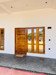 an empty room with wooden doors and windows at Azura Hotel in Pottuvil
