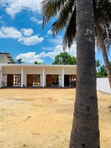a palm tree in front of a building at Azura Hotel in Pottuvil