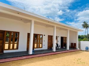 a large white house with columns and windows at Azura Hotel in Pottuvil