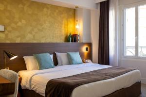 a hotel room with a large bed in a room at Hotel Parc Eiffel in Paris