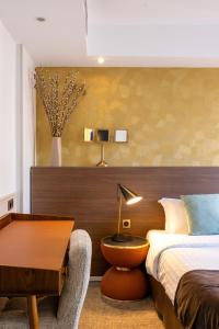 a bedroom with a bed and a desk and a table at Hotel Parc Eiffel in Paris