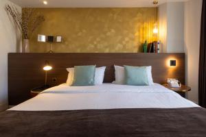 a bedroom with a large bed with a wooden headboard at Hotel Parc Eiffel in Paris +22 photos