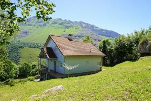 a small house on top of a grassy hill at Villa Pereza in Socueva