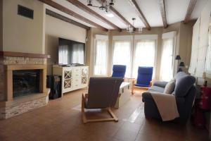 a living room with a couch and chairs and a fireplace at Villa Pereza in Socueva
