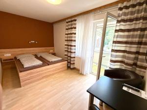 a room with two beds and a desk and a window at Gästehaus Kremser in Weiten