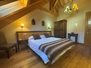 a bedroom with a large bed and a chair at Hostal Casa Otsoa in Ezcároz