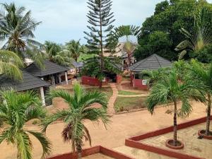 a resort with palm trees in front of houses at Palmgroove Hotel AND Bar, IDANYIN, IPERIN,OGUN STATE in Obisesan