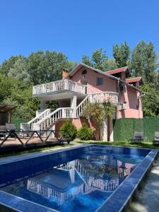 a house with a swimming pool in front of a house at Chalets & Rooms Čarda Šebešfok in Bezdan