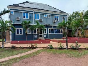 a blue house with solar panels on it at Palmgroove Hotel AND Bar, IDANYIN, IPERIN,OGUN STATE in Obisesan