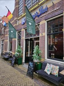a store with a bench in front of a building at King's Inn City Hostel Alkmaar in Alkmaar