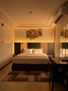 a bedroom with a large bed and a desk at Tulip Al Rawda Serviced Apartments in Riyadh +57 photos