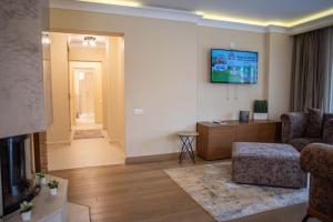 a living room with a couch and a tv at Expecto Apartments in Sinaia