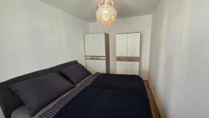 a bedroom with a black bed and a mirror at Appartement LUFT bei Wien in Klosterneuburg