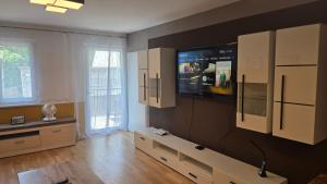 a living room with a tv on a wall at Appartement LUFT bei Wien in Klosterneuburg