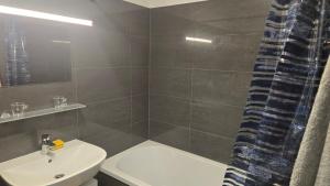 a bathroom with a sink and a toilet and a shower at Appartement LUFT bei Wien in Klosterneuburg +4 photos