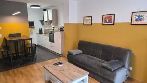 a living room with a couch and a kitchen at Appartement LUFT bei Wien in Klosterneuburg