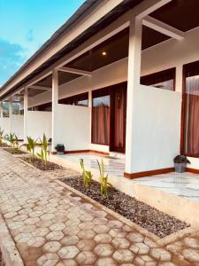 a white building with plants in front of it at Snooze hostel lombok in Selong Belanak