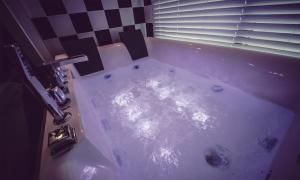 a tub with water in it in a bathroom at La Beaute Jeju Pension in Seogwipo +17 photos