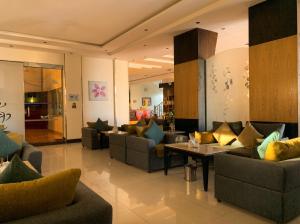 a lobby with couches and a table with pillows at Tulip Al Rawda Serviced Apartments in Riyadh