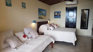 a living room with two beds and a couch at Casa Serena in Pipa
