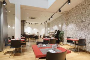 a restaurant with red tables and chairs and a wall at Exe Hotel El Magistral in Oviedo +28 photos