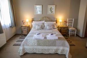 a bedroom with a large bed with towels on it at El lugar de la Flor in San Carlos de Bariloche