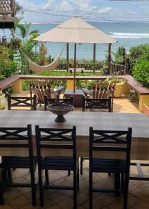 a table with chairs and an umbrella on a patio at Casa Serena in Pipa +39 photos