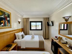 a hotel room with a bed and a television at Majliss Hotel Downtown in Rabat +82 photos