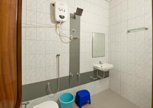 a bathroom with a shower and a toilet and a sink at Hotel yogeshwar in Mahesāna
