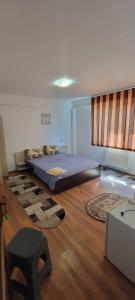 a bedroom with a bed on a wooden floor at LeoneG in Năvodari
