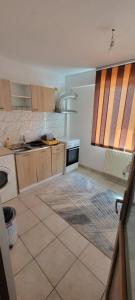 a kitchen with wooden cabinets and a tile floor at LeoneG in Năvodari