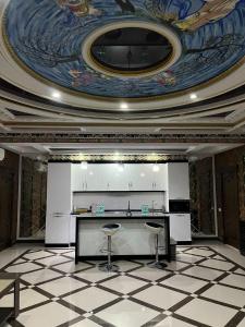 a room with a ceiling with a table and stools at Sunrise Apartments in Dushanbe