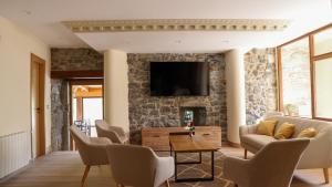 a living room with a tv on a stone wall at Posada VALLE DEL ASON in Ogarrio