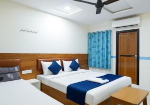 a bedroom with two beds and a blue curtain at Hotel yogeshwar in Mahesāna