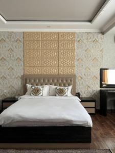 a bedroom with a large white bed and a piano at Sunrise Apartments in Dushanbe