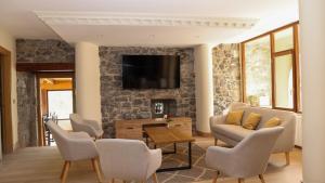 a living room with a tv on a stone wall at Posada VALLE DEL ASON in Ogarrio +56 photos