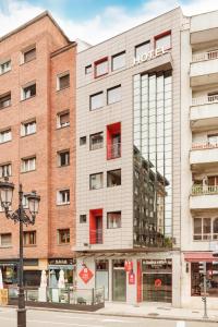 a building with a hotel sign on the side of it at Exe Hotel El Magistral in Oviedo