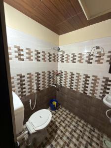 a bathroom with a toilet and a sink at Hayath Homes in Athirappilly