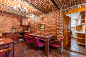 a brick walled kitchen with a wooden table and chairs at Cherry Tree Sibiu in Sibiu