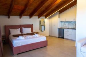 a bedroom with a large bed and a kitchen at PERDIKA's HORIZON in Perdika