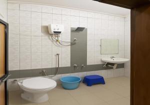a bathroom with a toilet and a sink at Hotel yogeshwar in Mahesāna +6 photos