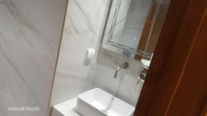 a white bathroom with a sink and a mirror at Elin house in Hammamet +4 photos
