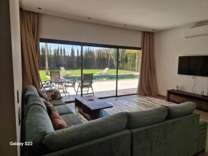 a living room with a couch and a large window at Agadir sans vis a vis in Bouria