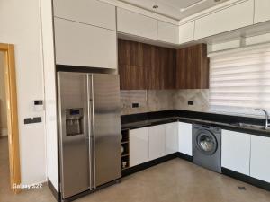 a kitchen with a refrigerator and a washing machine at Agadir sans vis a vis in Bouria