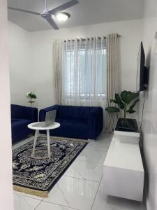 a living room with a blue couch and a laptop on a table at Bellah Homes in Bamburi